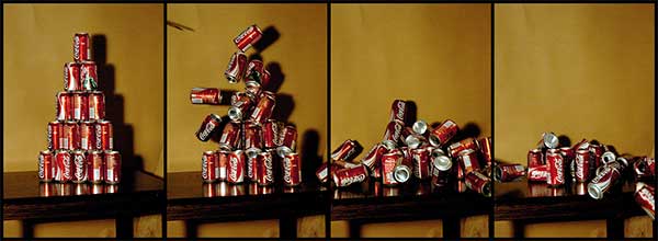 Image sequence of a tower of coke cans being hit by a shot from the Super Maul